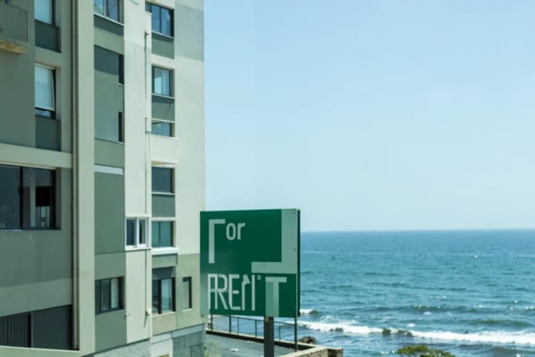 Placa de "Aluga-se" em frente a um apartamento com vista para o mar em Fortaleza