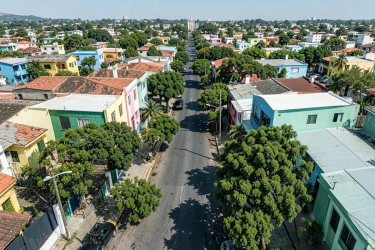 Vista aérea de um bairro residencial em Fortaleza com casas coloridas e ruas arborizadas.