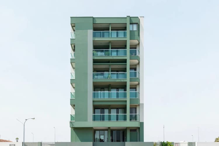 Fachada de um prédio residencial moderno em Fortaleza, com varanda e detalhes arquitetônicos.