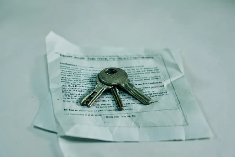 Chaves de um apartamento em cima de um contrato de aluguel.